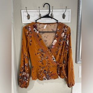 Long sleeve, low cut blouse with floral print. Great color for fall!
